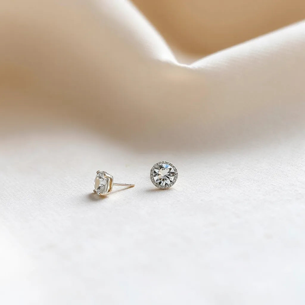 Faceted moissanite earrings resting on neutral fabric with soft natural light and shallow depth of field