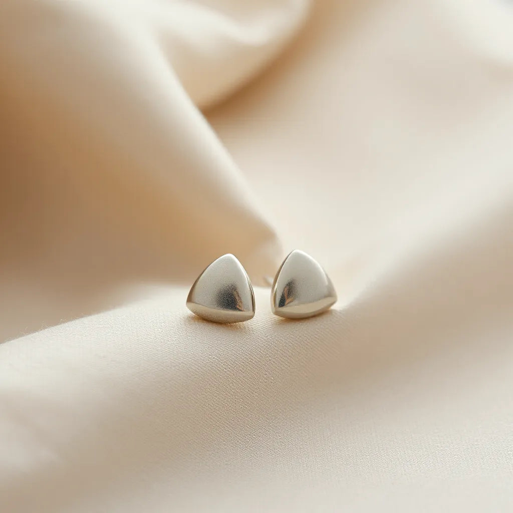 Lightweight stud earrings with secure backs resting on soft fabric