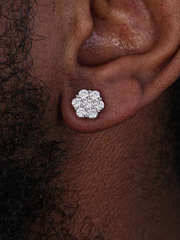 Close-up of an ear wearing a diamond stud earring with a dark background